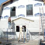 Finishing the outside with rot resistant cement based siding. Flashing and connection points left for later entry roof that was completed by owner.